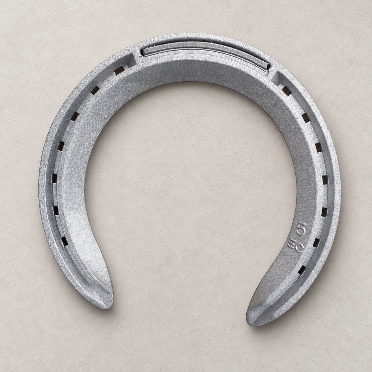 Forged aluminum horseshoe showing a matte silver surface and the reference nail-hole pattern