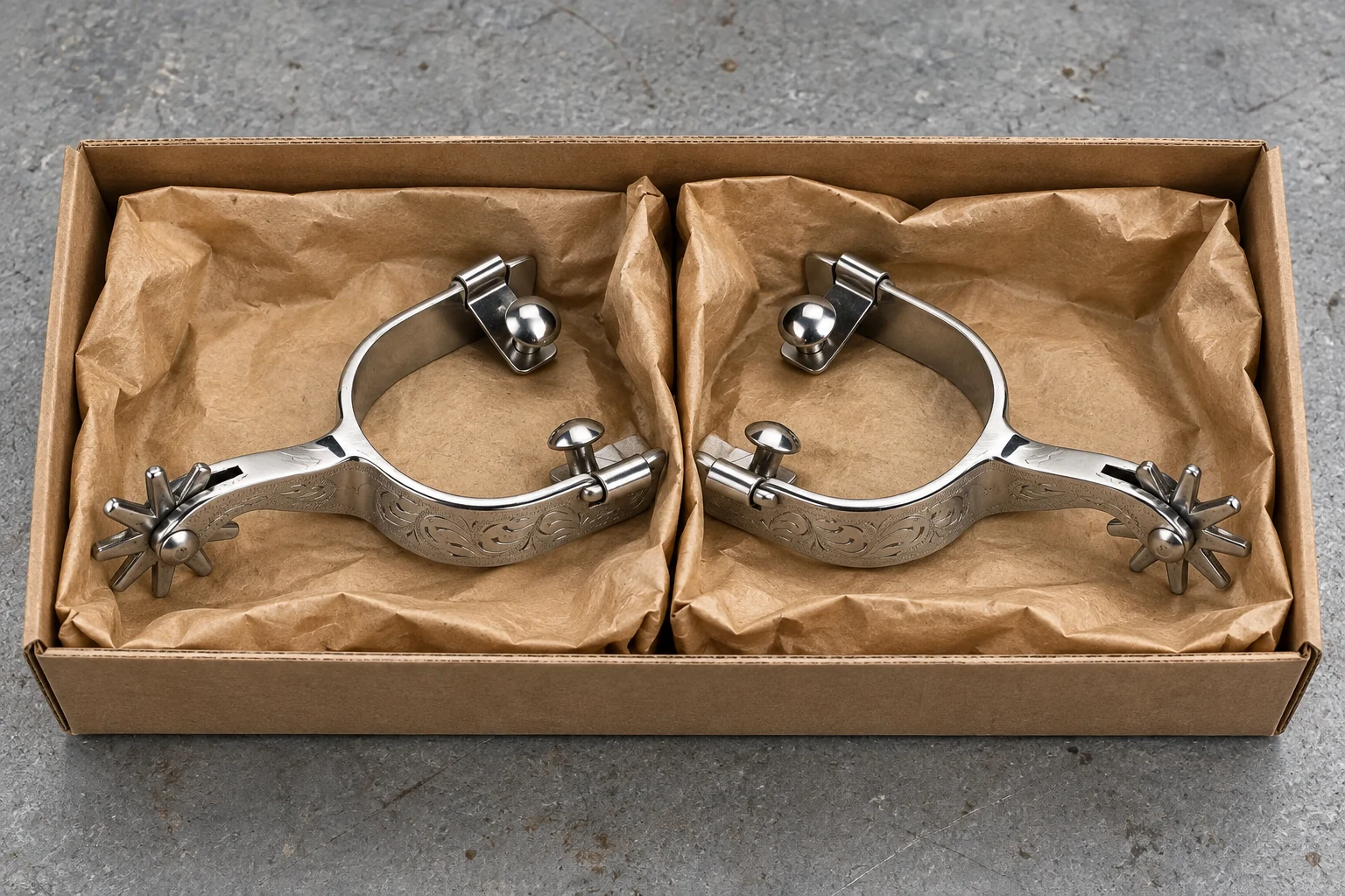 Paired Western spurs separated inside protective kraft packaging