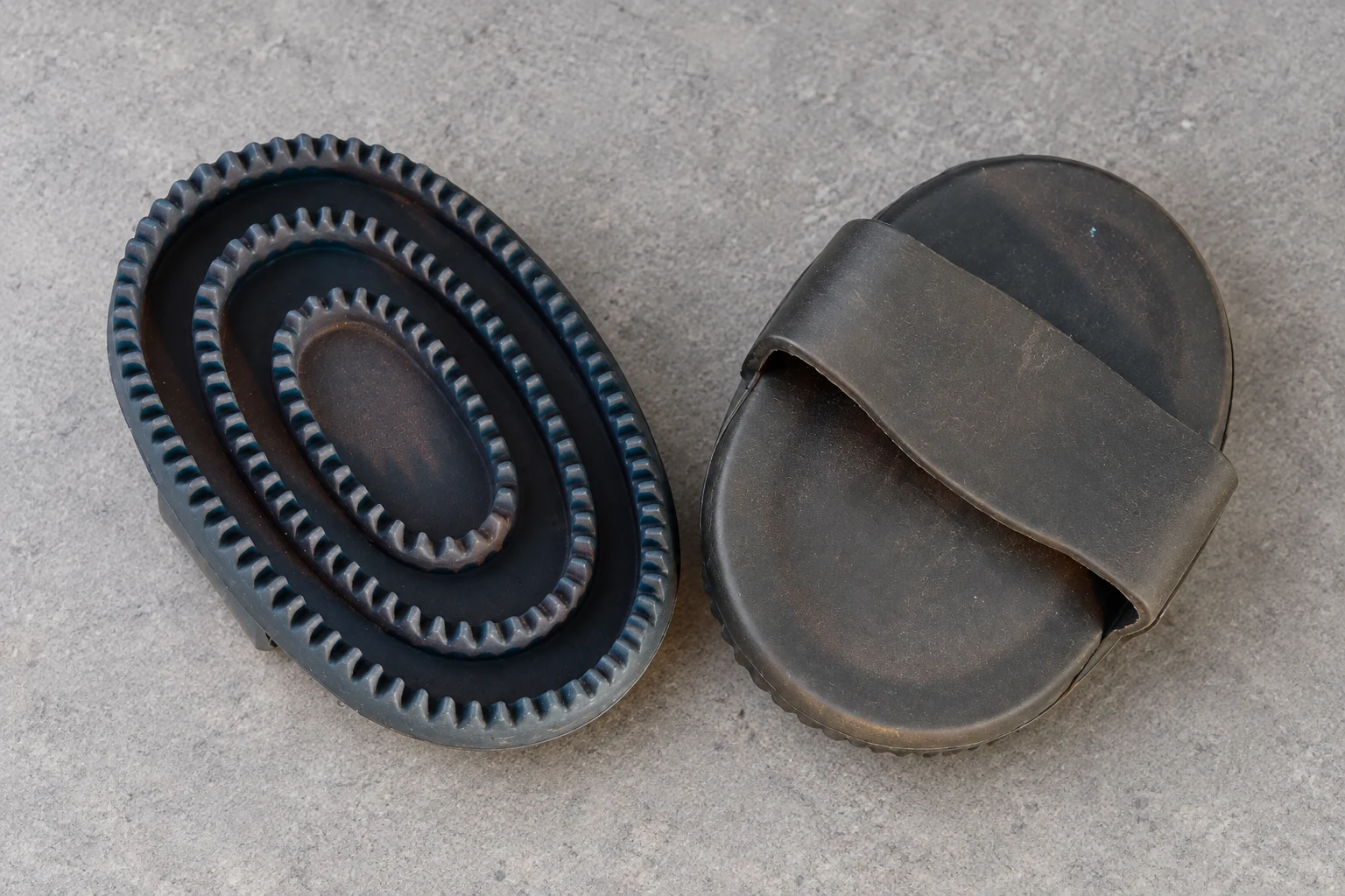 Rubber curry comb showing its textured face and hand strap