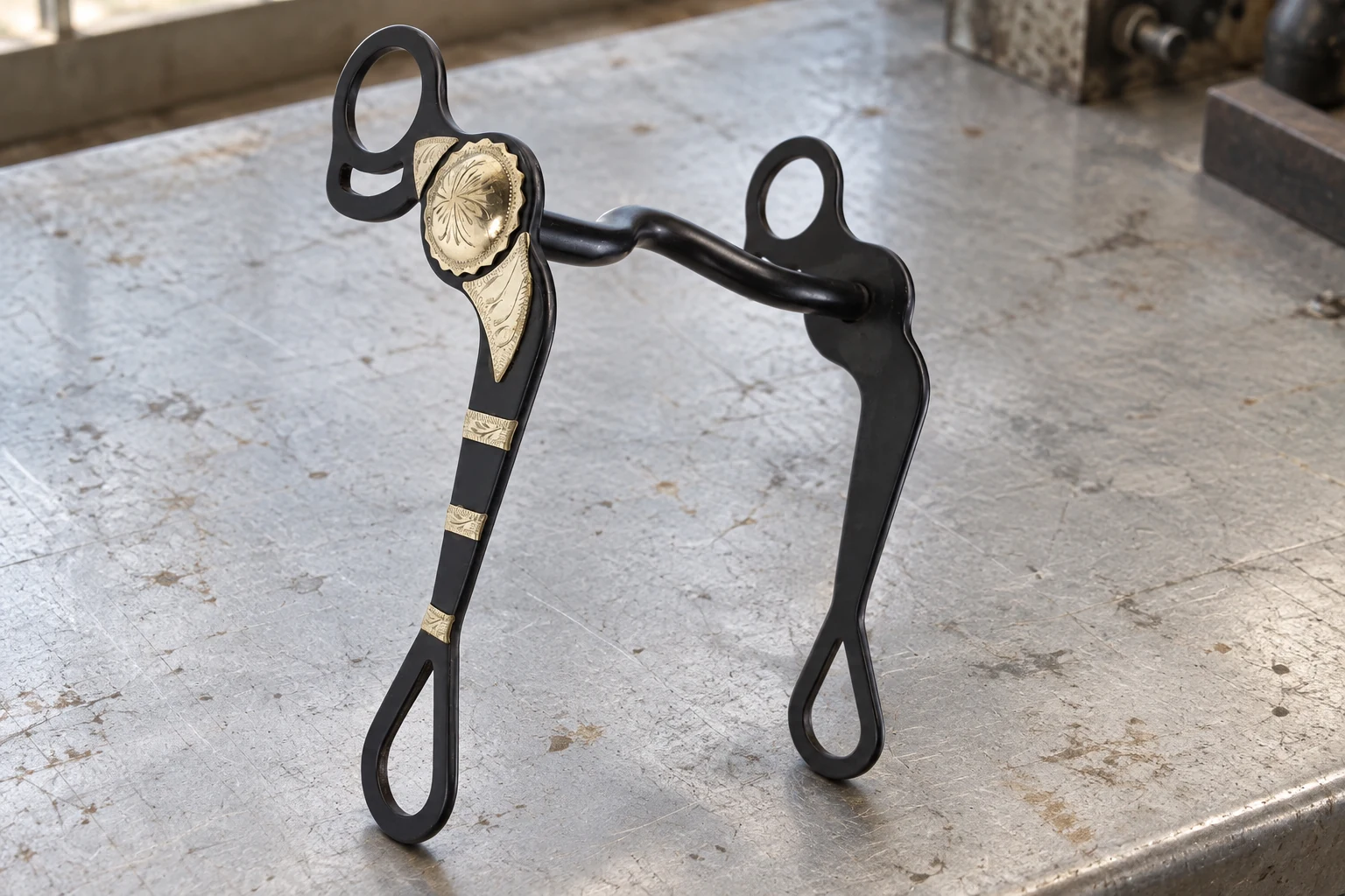 Dark Western show bit with decorative trim on a workshop bench